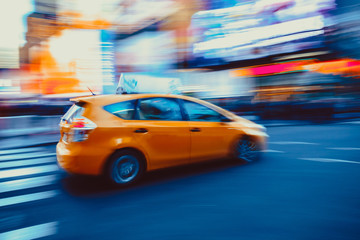 Abstract motion blurred New York City taxi driving fast on city street blurred background