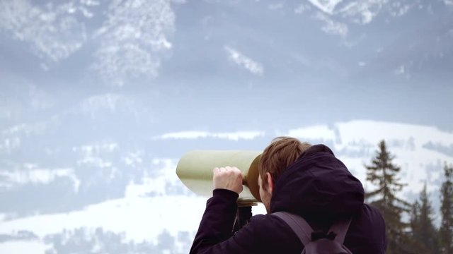 Man looking mountain through monocular binocular on tv tower