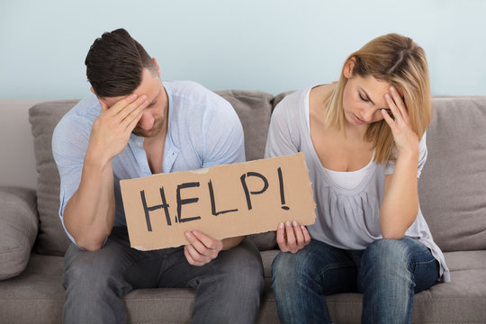 Worried Couple Holding Help Sign