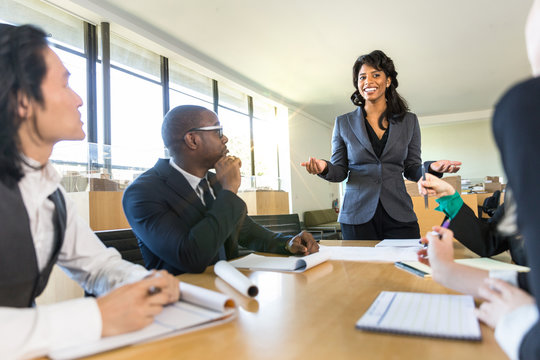 CEO boss female speaker manager presenting a lecture in the boardroom office workplace to colleagues 
