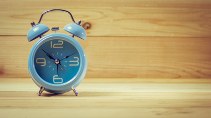 Sky alarm clock on wood table. Photo in retro color image style.