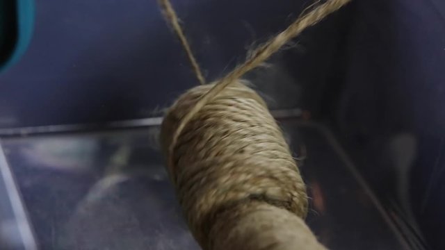 artist unrolls twine rope for project