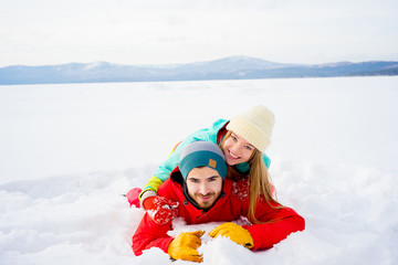 Fototapeta na wymiar Happy couple lying in snow