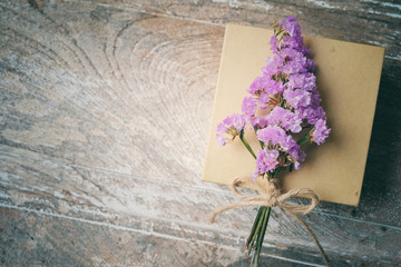  Flower bouquet  and gift box on wooden background.
