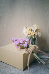 Flowers and present gift on wooden background/ Holiday background.