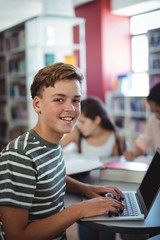 Attentive student using laptop in library