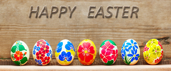 Easter eggs with a hand-drawn floral pattern on a wooden background
