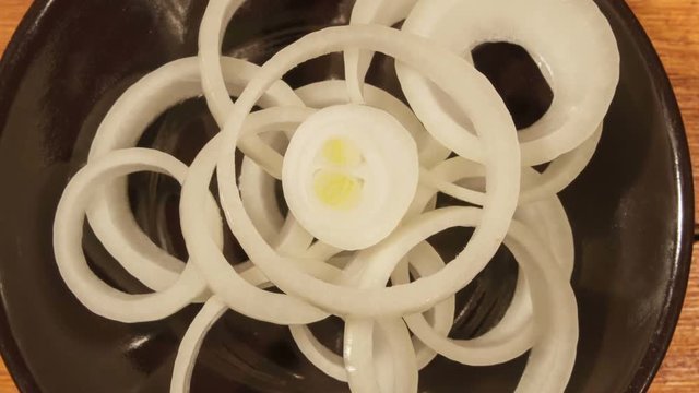 Sliced fresh onion on wooden table.