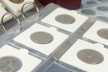 Coins in the album. Selective focus.