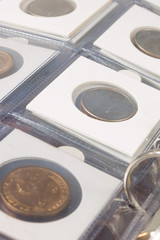 Coins in the album. Selective focus.
