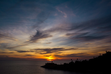 Naklejka na ściany i meble Cloudy sky and the shoreline in sunset. The cloudy sunset and the silhouette of shoreline. Horizontal outdoors shot.