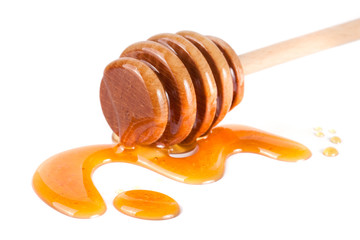 Honey stick with flowing honey isolated on white background