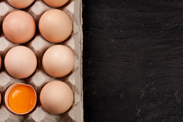 eggs in a tray on a dark background with copy space for your text. Top view