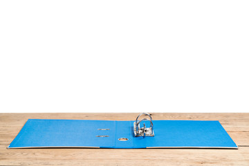 An open clerical folder for storing documents a blue with clip, lying on a wooden table on a white background