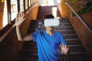 Schoolboy using virtual reality headset on staircase