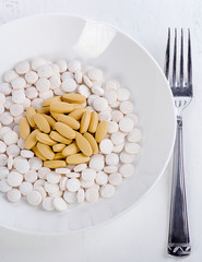 Plate with pills and fork. Medical and diet concept.