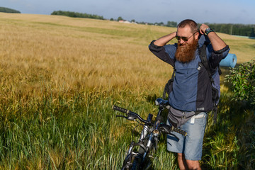 hipster man on a bicycle in the field