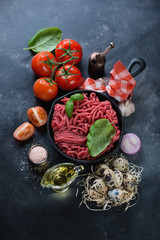 Raw minced meat and other ingredients for preparing bolognese sauce, high angle view