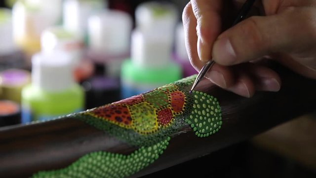 artist paints dots of sea turtle for didgeridoo pointillism