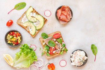 Two different open sandwiches from whole grain bread with ingredients on rustic surface