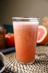 grapefruit juice in clear glass on wooden table 