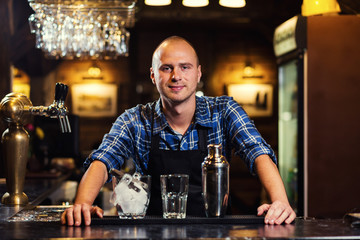 Barman at work,Barman pouring hard spirit into glasses in detail,Bartender is pouring tequila into glass,preparing cocktails,service concept