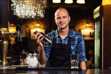 Barman at work,Barman pouring hard spirit into glasses in detail,Bartender is pouring tequila into glass,preparing cocktails,service concept