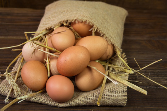 Chicken eggs in bag on wooden background