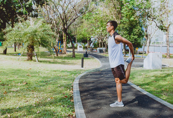 Young man stretching bodies, warming up for jogging.