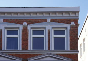 Fototapeta na wymiar Fenster in einer Fassade eines Hauses