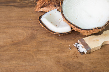 Coconut and coconut grater on wooden background.