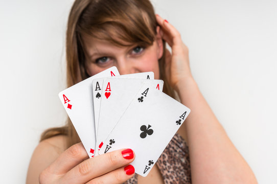 Beautiful girl hides behind poker cards
