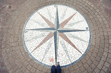 In which way? Mosaic compass rose background and woman sneakers.