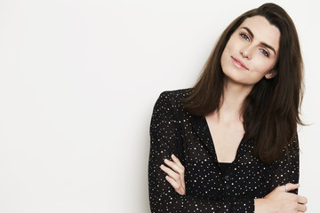 Fototapeta premium Portrait of brunette woman in black top, smiling