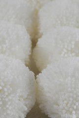 Fototapeta na wymiar White fluffy woolen pompoms background. Woolen texture
