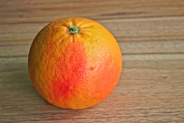 Closeup of a red grapefruit on a wooden table