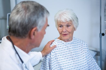 Doctor consoling senior patient