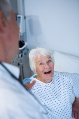 Doctor interacting with senior patient in ward