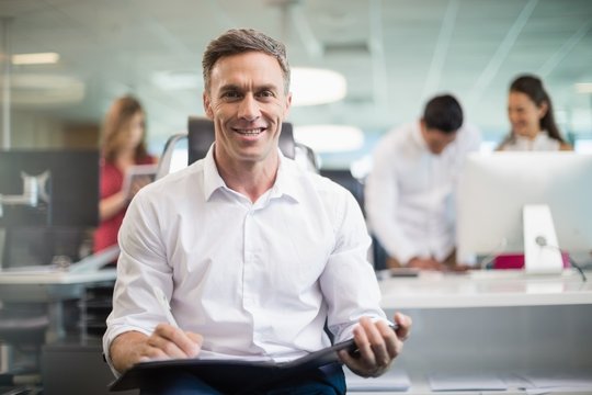 Smiling business executive sitting on chair 