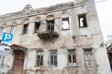 Ruined disastrous building with broken windows and iron lattice