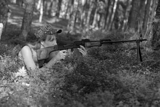 Beautiful girl in the woods with a machine gun Kalashnikov
