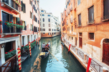 Fototapeta na wymiar Gondolas on canal in Venice. Venice is a popular tourist destination of Europe.