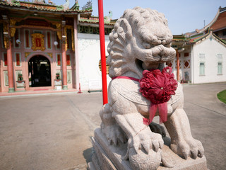 Guardian lion statue in front of Chinese temple