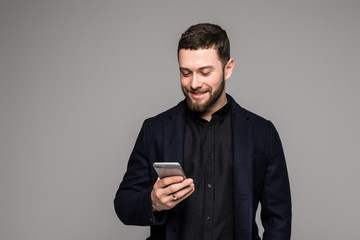 Happy man in black suit typing sms on smartphone