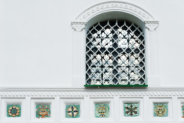 Window with lattice and tiles decoration of Trinity cathedral in Pskov Kremlin