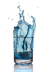 Splash in glass of blue alcoholic cocktail drink with ice cube
