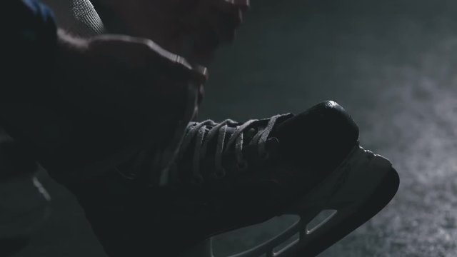 Hockey player tie shoelaces on skates close-up