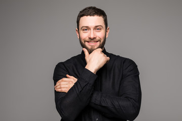 Happy young man. Portrait of handsome young man in casual shirt smiling while standing against grey background