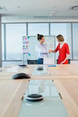 Obraz premium Smiling business colleagues shaking hands in conference room