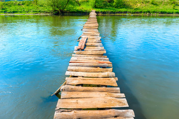Old wooden bridge through the river